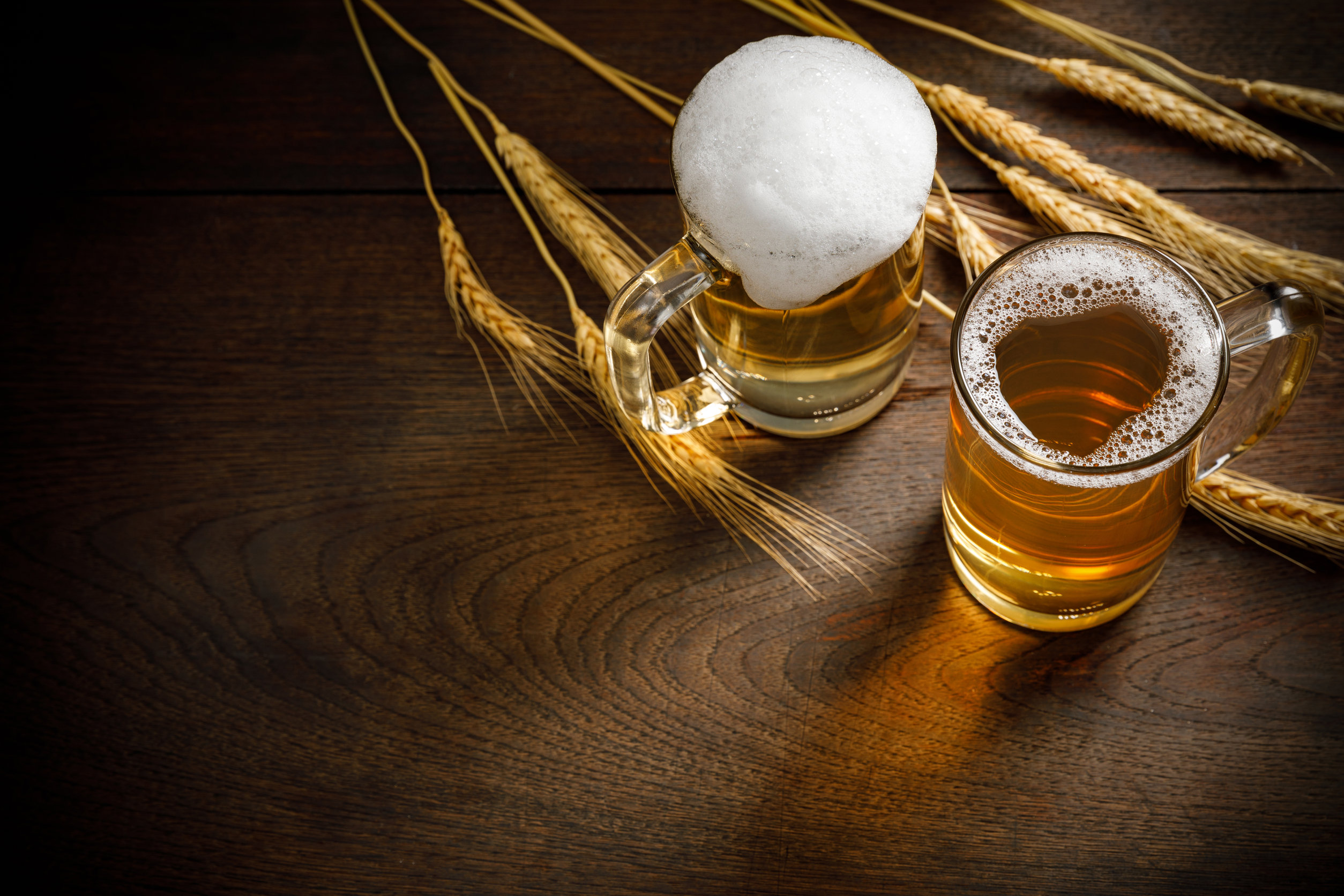 Glasses of Light Beer with wheat on the wooden table, copy space